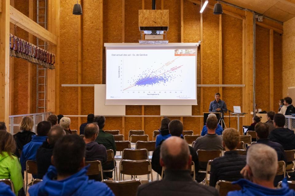 Das Publikum wohnt der Konferenz auf dem Schulbauernhof in Grangeneuve bei.